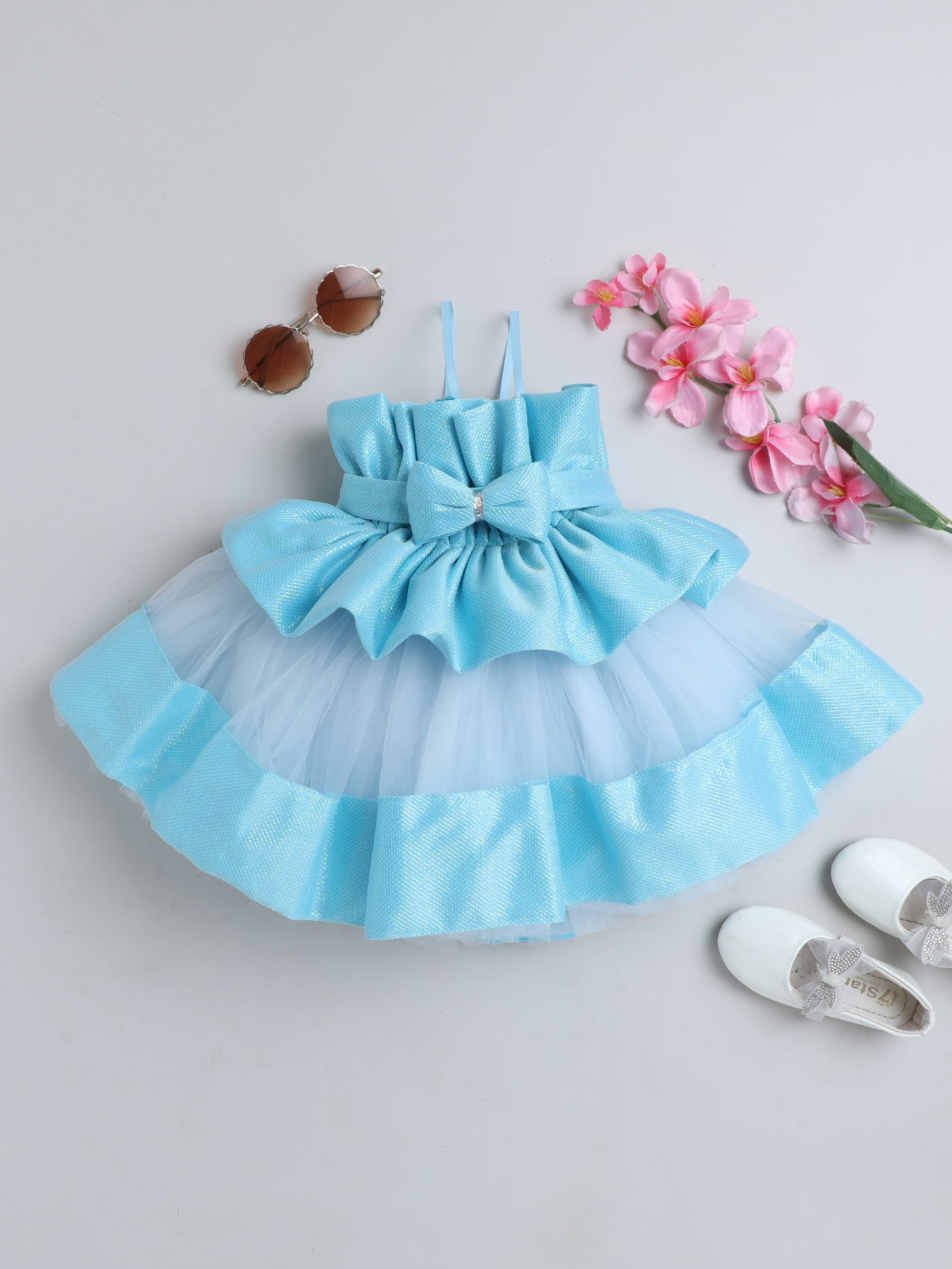 "Dreamy tutu gown featuring a shimmery bow belt, layered ruffles, and delicate straps – perfect for birthdays,
