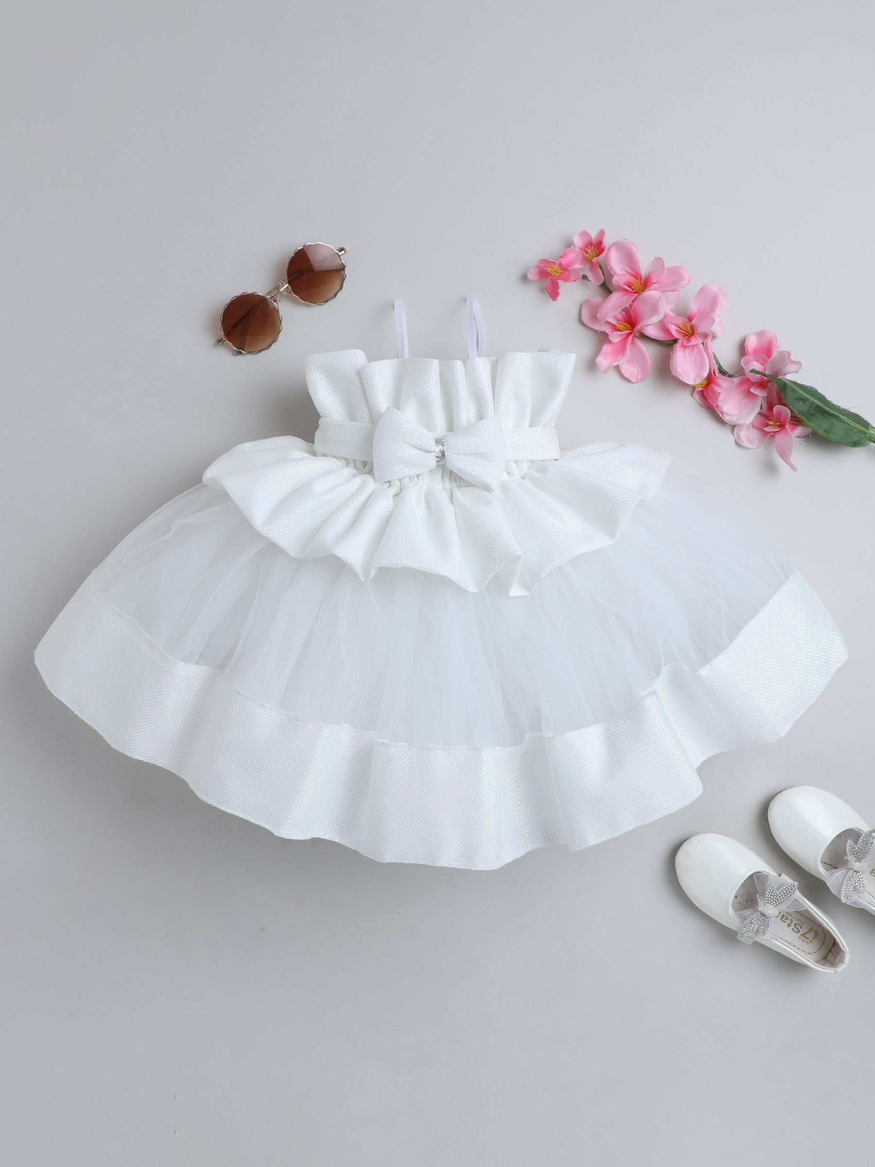 "Dreamy tutu gown featuring a shimmery bow belt, layered ruffles, and delicate straps – perfect for birthdays,